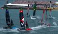 Teams round the finish marker in front of the grandstand full of spectators on Race Day 2 of The Rolex SailGP Championship ITM New Zealand Sail Grand Prix in Auckland