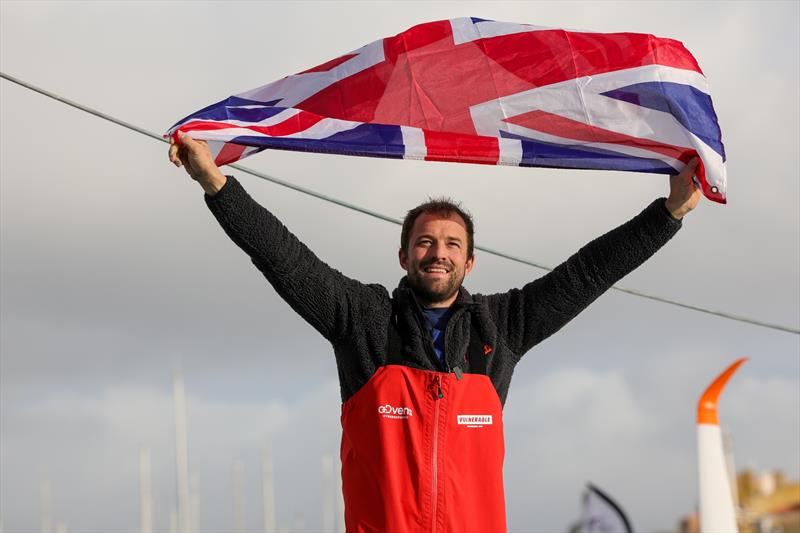 Vulnerable skipper Sam Goodchild (GBR) is photographed with a UK flag after taking 9th place in the Vendée Globe - photo © Jean-Marie Liot / Alea