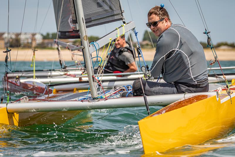 William Dawson can't resist a smile as he narrowly sneaks over the line ahead of Dan Jarman on day 2 of the Unicorn and A Class Catamaran Nationals at Hayling Ferry SC - photo © Gordon Upton / www.guppypix.com